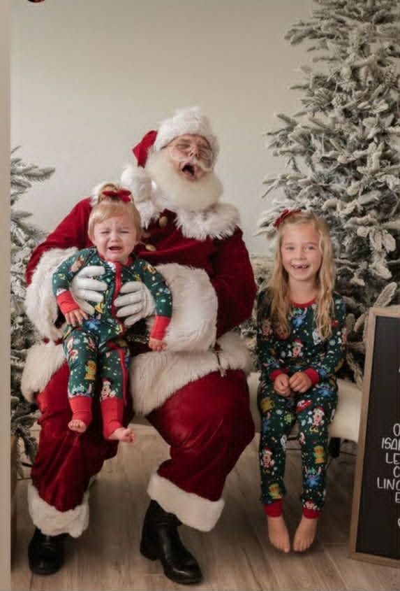 Santa holding a crying toddler while her older sister sits beside him laughing